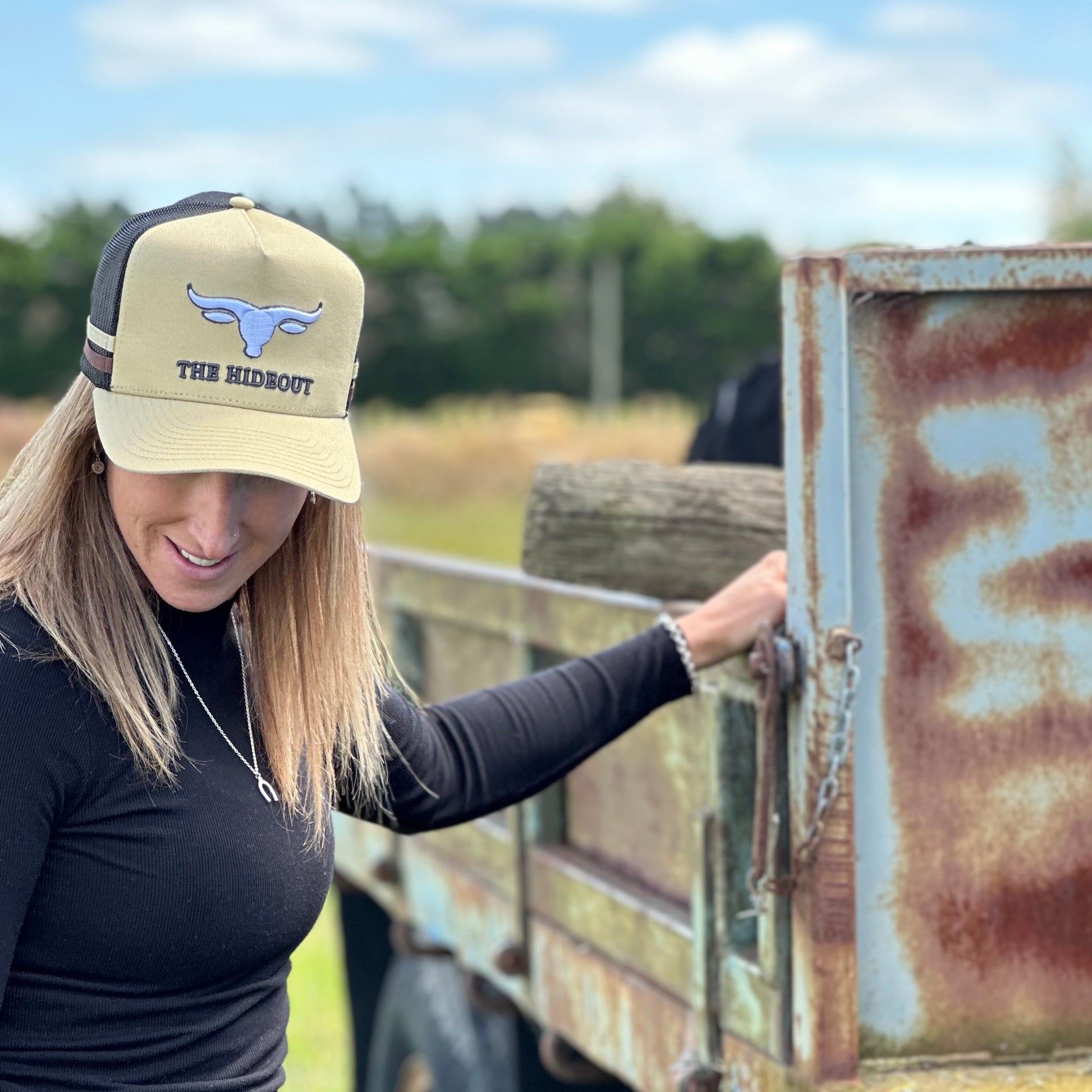 Beige and charcoal trucker cap with logo and photo under brim