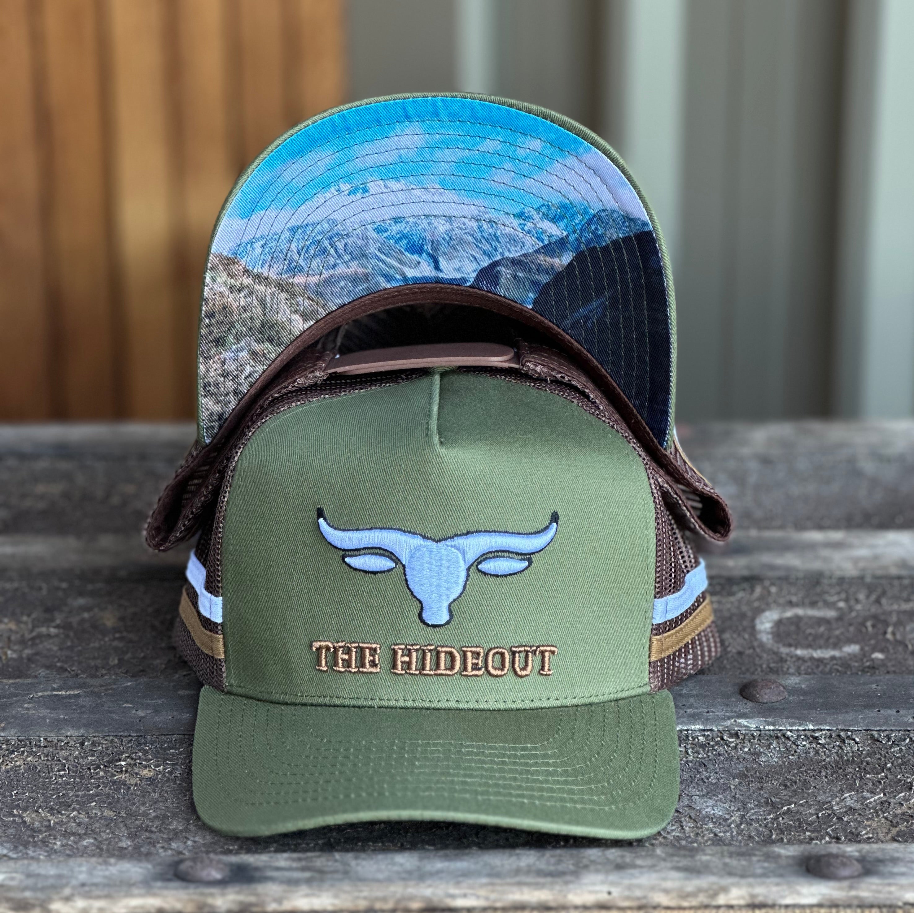 Green and brown trucker cap with logo and photo under brim