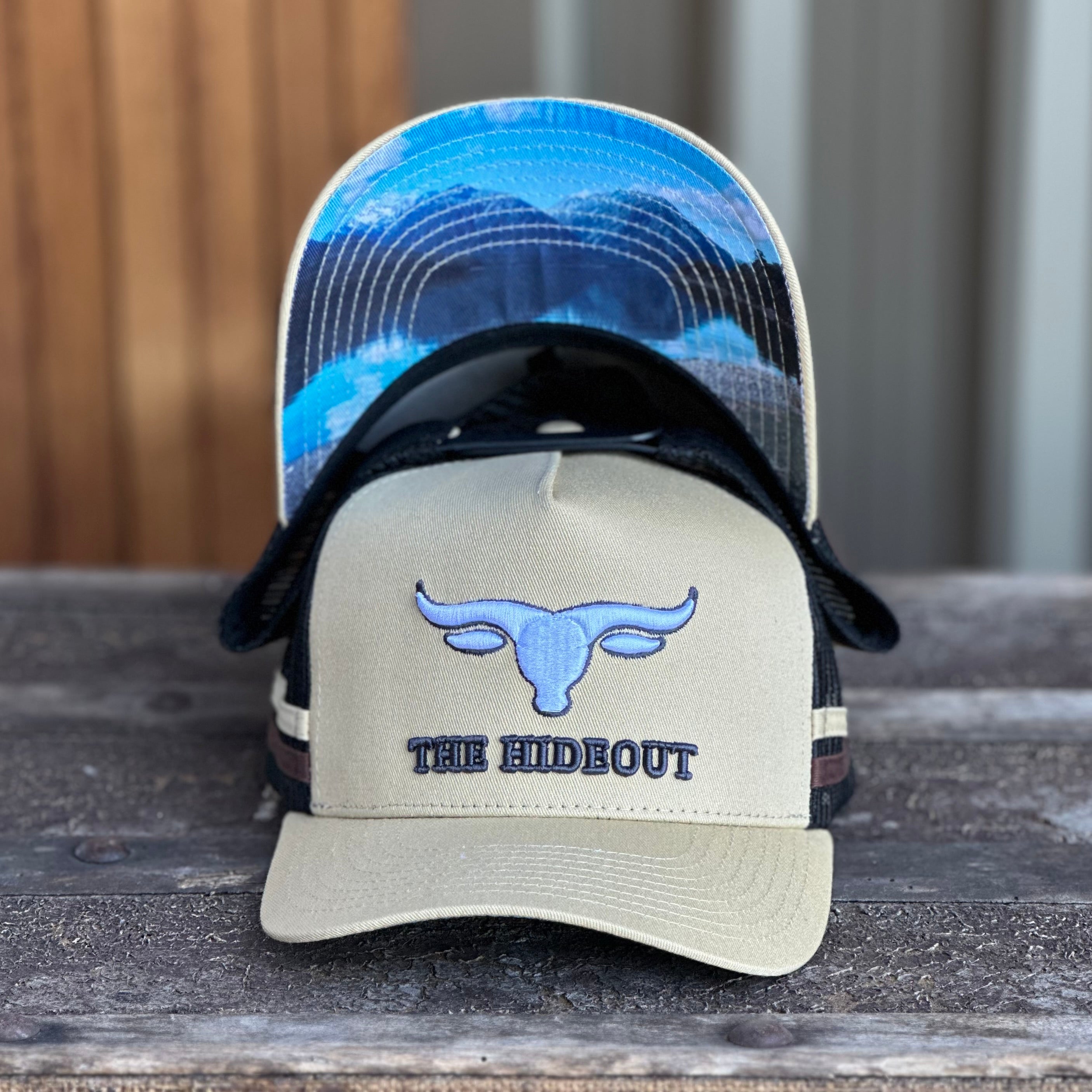 Beige and charcoal trucker cap with logo and photo under brim