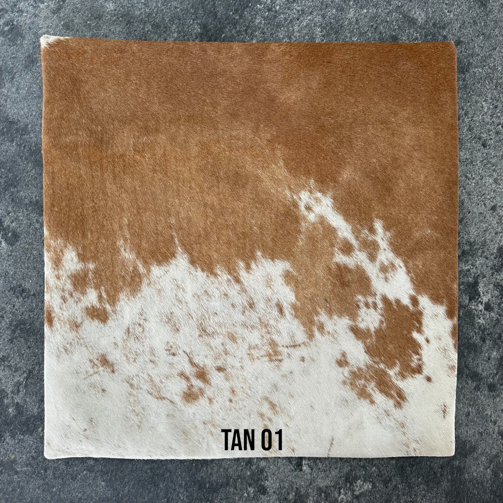 Tan and white cowhide cushion