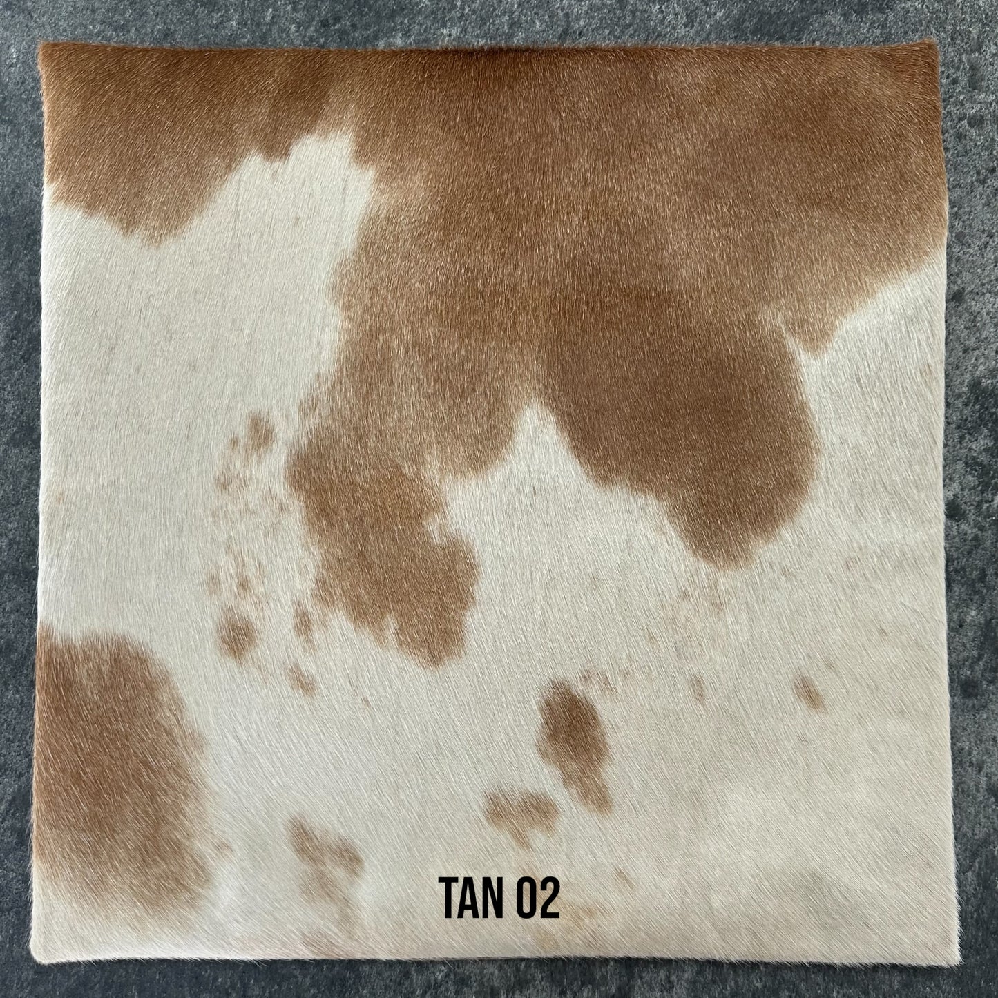 Tan and white cowhide cushion