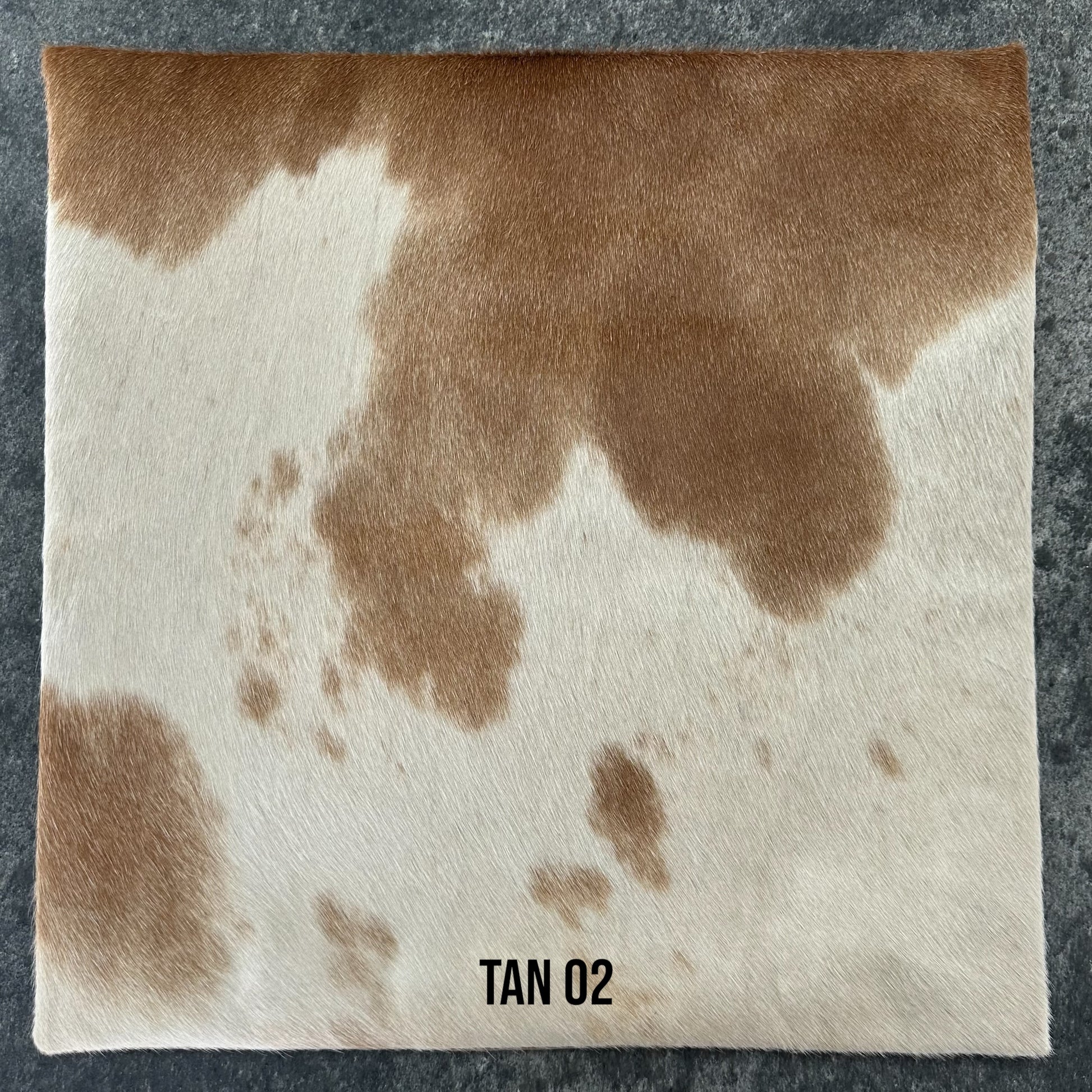 Tan and white cowhide cushion