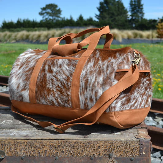 Cowhide and leather weekend travel bag in tan and white