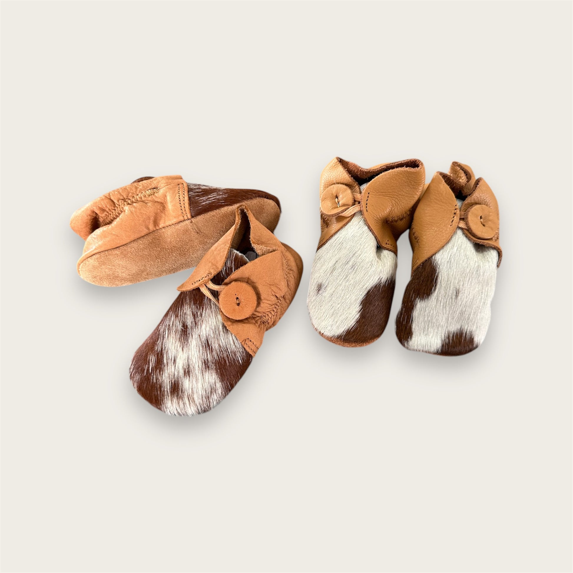 Cowhide and leather baby booties in tan and white