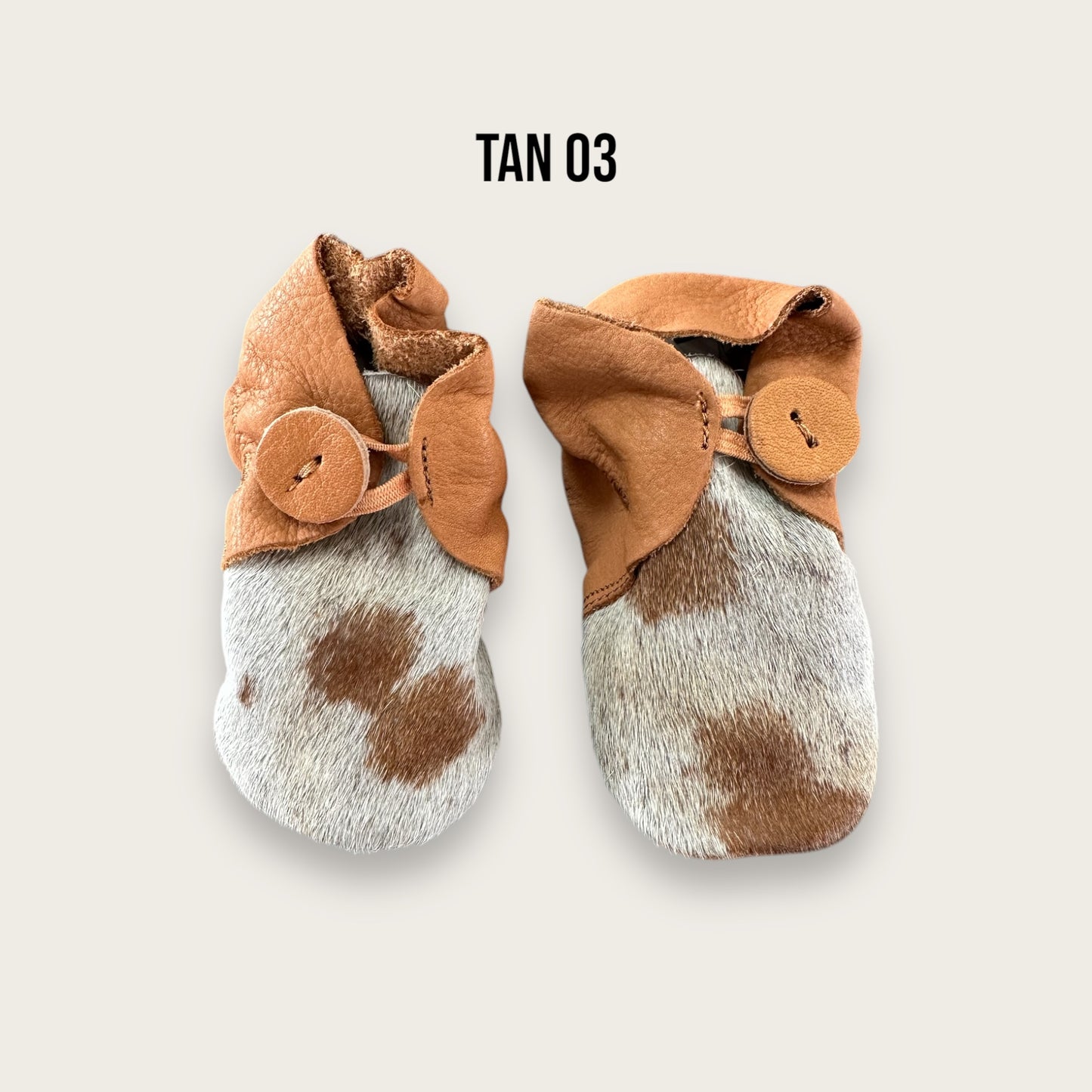 Leather and cowhide baby booties in tan and white
