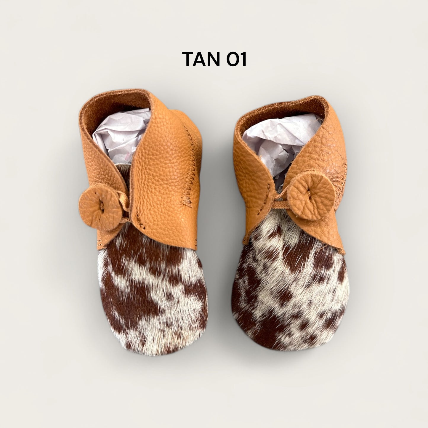 Leather and cowhide baby booties in tan and white