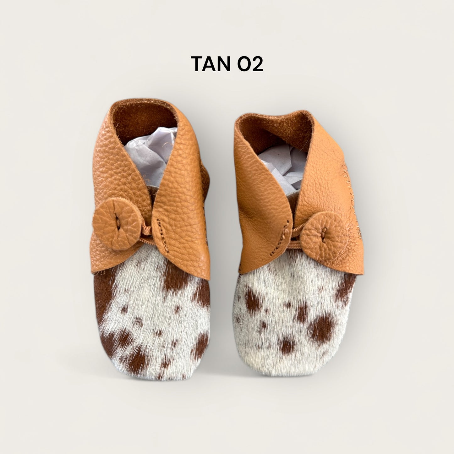 Leather and cowhide baby booties in tan and white
